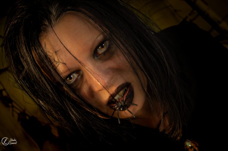 Femme avec un maquillage sombre, regard intense et cheveux longs et noirs.